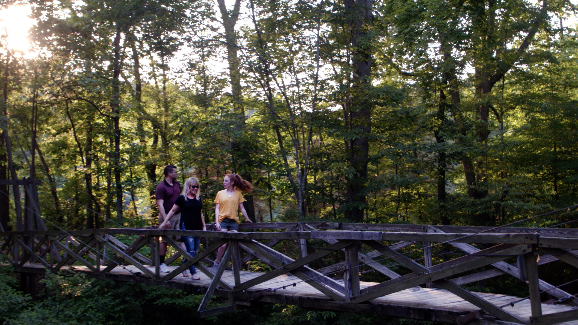People walk across a bridge near our mental health workshop campus.